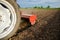 A tractor with a cutter unit is cultivating the field. Loose crushed moist soil after cultivating with a cultivator. Loosening