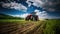 Tractor Diligently Cultivating A Field During Springtime