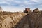 Tractor with double wheeled ditcher digging drainage canal.