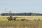 Tractor dragging a harrow in field