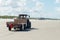 Tractor drives on the beach with a trailer