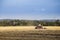 Tractor driving in field, autumn rural landscape