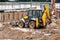 Tractor excavator with bucket rides running through mud lands setting, view from the height