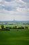 Tractor in farm field in front of a wind turbine generating clean energy in SkÃ¥ne Sweden