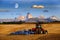 Tractor Farming Ground Harvesting Crops in Fall Autumn Teton Mountains Rugged with Moon