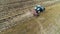 Tractor and feeding storks in a field, agriculture landscape