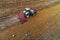 Tractor and feeding storks in a field, agriculture landscape, aerial view