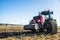 Tractor in the field. Agricultural machinery. Agricultural farm tractor during tillage of soil and field after harvest.