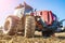 Tractor in the field. Agricultural machinery. Agricultural farm tractor during tillage of soil and field after harvest.