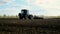 The tractor on the field cultivates the soil. Selective focus.