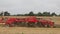 Tractor in a field cultivating the soil in preparation for seeding. UK