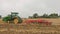 Tractor in a field cultivating the soil in preparation for seeding. UK