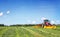 Tractor on the field, surrounded by storks