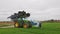 Tractor with a folded slurry spreader in a field.