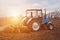 The tractor goes and pulls a plow,plowing a field before landing of crops.