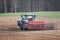 Tractor with a grain seeder in the field