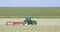 Tractor and grass turner work in dutch meadow