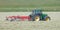 Tractor and grass turner work in dutch meadow