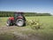 Tractor and grass turner work in dutch meadow in the province of south holland in the netherlands