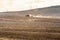 tractor harrowing the large brown field