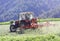 Tractor with hay tedder working on a mountain field