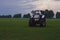 tractor with head lights in field at dusk