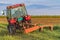 A tractor with implements mower cuts clover. Tractor mowing paddock