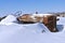 Tractor in a junkyard partially buried in snow