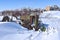 Tractor in a junkyard partially buried in snow