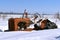 Tractor in a junkyard partially buried in snow