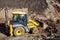 Tractor loader backhoe digger loader on a construction site with blue sky and dramatic clouds