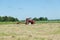 Tractor machine equipment ted dry grass in field