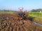 tractor in the middle of rice field with a lot of mud