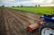 A tractor with a milling machine is cultivating a farm field. Loose crushed moist soil after cultivating with a cultivator