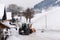 Tractor with milling and rotor snowplow equipment cleaning the street from the snow cover