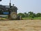 A tractor mounted with front grader is preparing an entrance ramp connected between higher and lower lands