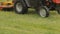 Tractor mows the grass in the rain, close-up