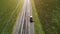 Tractor mows the roadside along the road aerial view