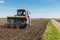 Tractor plough at bare Dutch field in early springtime