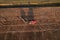 Tractor with Plough on Plowed. Ploughing and Soil Tillage. Agricultural Tractor on Cultivation Field for Sowing Seeds. Big Tractor