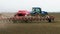 Tractor ploughs tills plows and seeds on the field