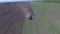 Tractor plowing the field . Chinese farmer on a small tractor plowing a field in spring day. Static, medium shot.