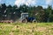 A tractor plows the field on a bright Sunny day. Rural spring landscape.