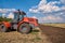 Tractor plows field, cultivators soil for sowing