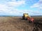 Tractor plows field. Tractor rides on the field and plows arable land.  Details and close-up.