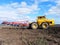 Tractor plows field. Tractor rides on the field and plows arable land.  Details and close-up.