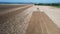 The tractor plows the soil with harrows. View from the drone. The agricultural machinery is equipped with GPS.