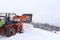 The tractor pours snow with his bucket on the ski slope. The work of the snowcat in the winter time. Preparation of the sports