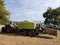 the tractor pulls the combine, which collects the hay from the fields and turns it into briquettes