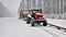 The tractor pulls a snowy car in the snow in winter landscape in